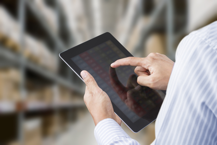 Businessman checking inventory in stock room on tablet